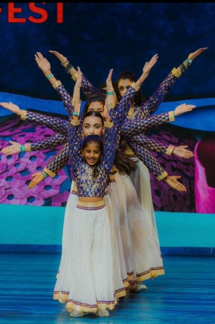 A dancer with a peacock-feather costume on the showcase stage