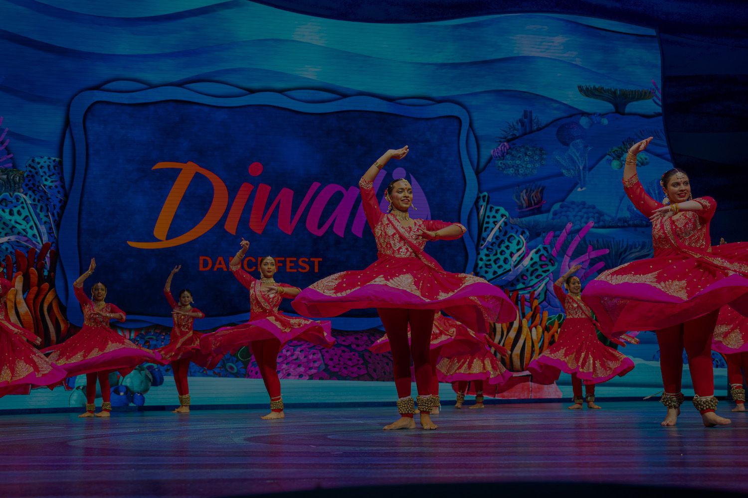 Dancers in red twirling on stage at the 2025 showcase
